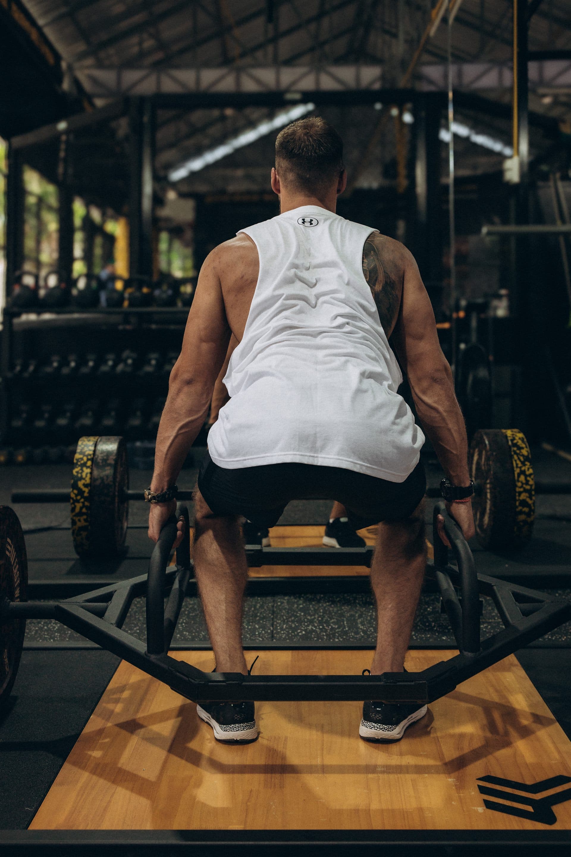 Артур выполняет тягу трап-грифом в зале BENCH FITNESS